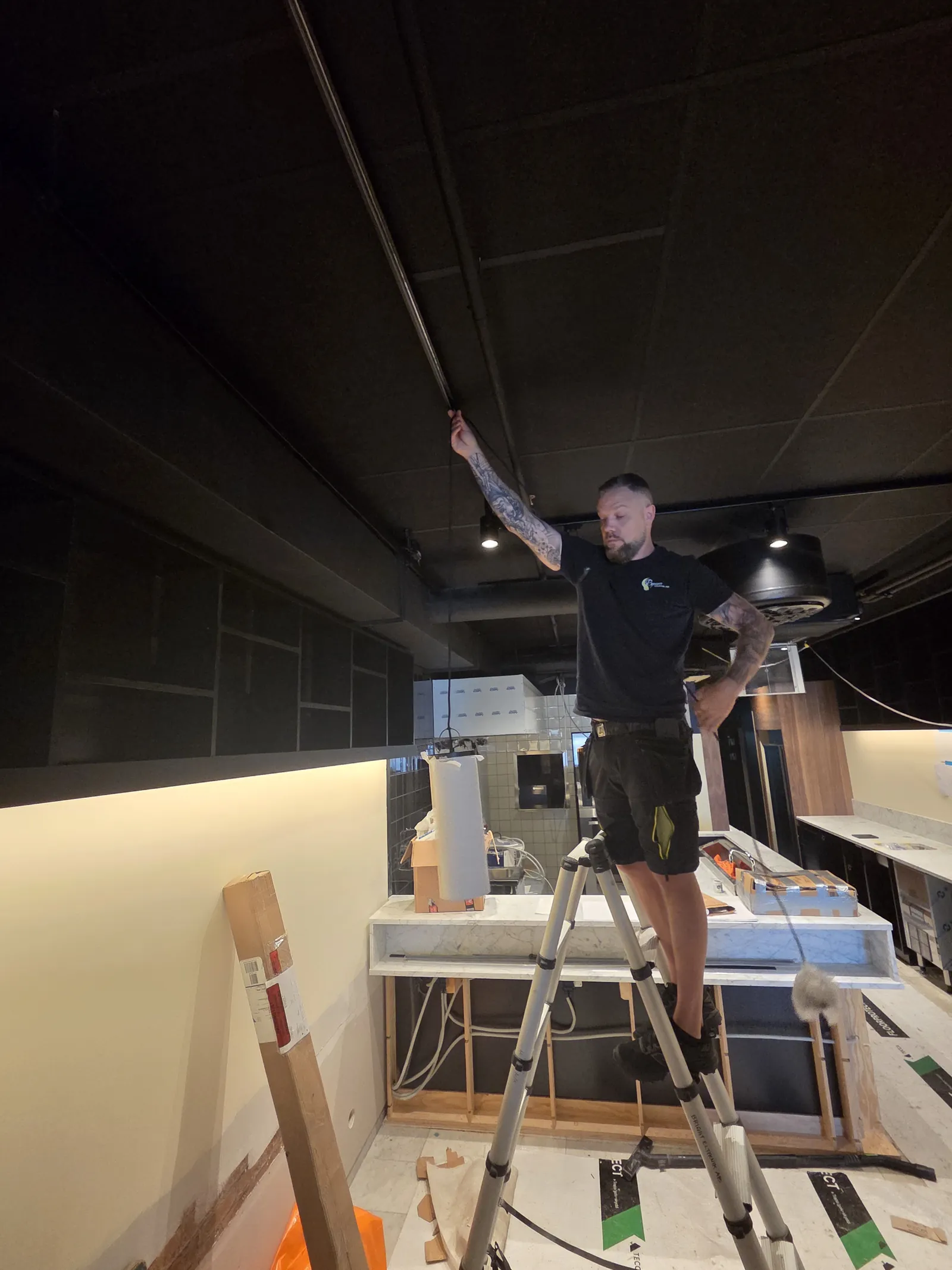 Elektriker monterar belysning i lokal